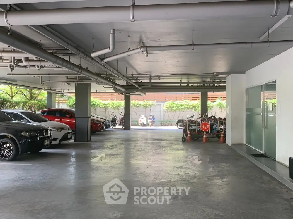 Spacious indoor parking area with multiple cars and natural light