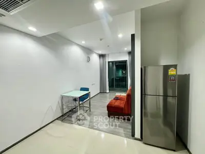 Modern apartment interior with sleek fridge and cozy seating area