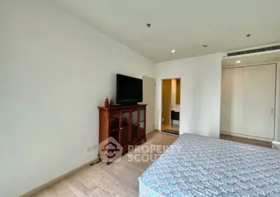 Spacious bedroom with modern decor and flat-screen TV in a stylish apartment.