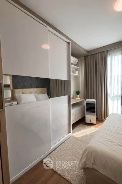 Modern bedroom with sleek wardrobe and natural light, perfect for cozy living.