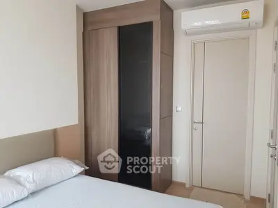 Modern bedroom with sleek wardrobe and air conditioning unit.