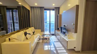 Modern living room with stylish decor and large windows offering city views.