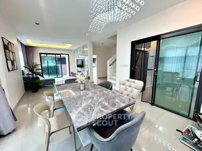 Luxurious modern dining area with elegant marble table and chic lighting in open-concept living space.
