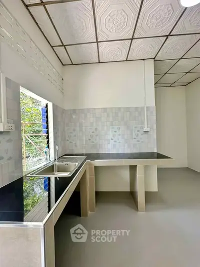 Modern kitchen with sleek countertops and stylish backsplash in a bright, airy space.