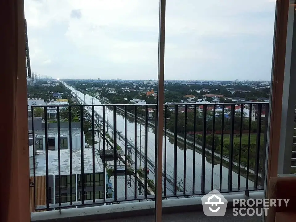 Stunning high-rise balcony view overlooking a serene river and cityscape, perfect for urban living.