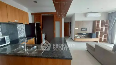 Modern open-plan kitchen and living room with sleek design and appliances.