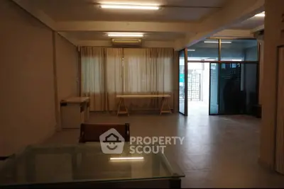 Spacious open-plan living area with large windows and modern furnishings, ideal for contemporary living.
