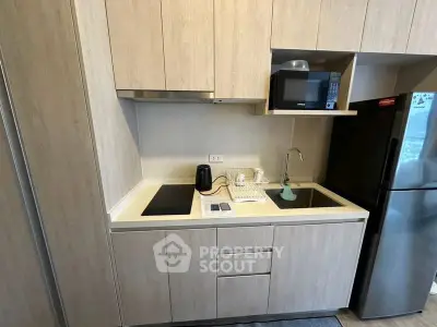 Modern compact kitchen with sleek cabinetry and appliances in a stylish apartment.
