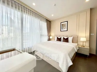 Luxurious bedroom with elegant decor and large windows in modern apartment.