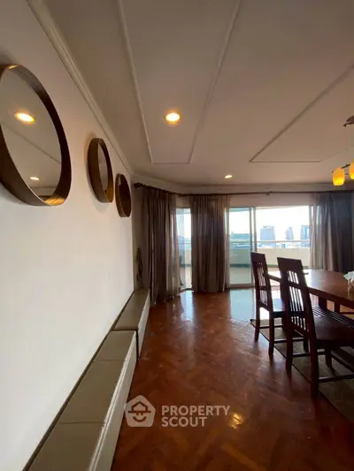 Spacious dining area with parquet flooring and city view balcony access.