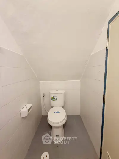 Compact bathroom with sloped ceiling and modern fixtures