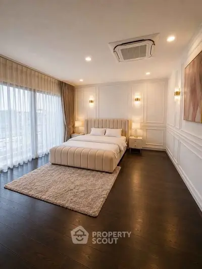 Luxurious bedroom with elegant decor and large windows offering natural light.