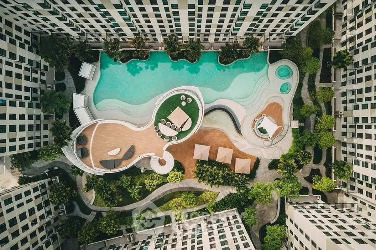 Stunning aerial view of luxurious residential pool area with modern design and lush greenery.