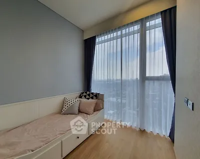 Cozy bedroom with large window and stylish decor in modern apartment