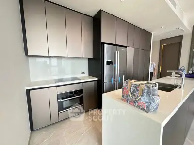 Modern kitchen with sleek cabinetry and stainless steel appliances in a luxury apartment.