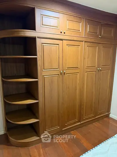 Spacious wooden wardrobe with ample storage in elegant interior setting.
