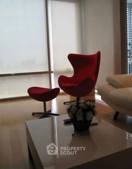 Modern living room with red designer chair and city view