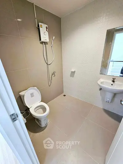 Modern bathroom with sleek tiles and compact fixtures in a contemporary apartment.