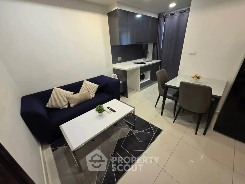 Modern compact living room with sleek kitchen and dining area, perfect for urban living.