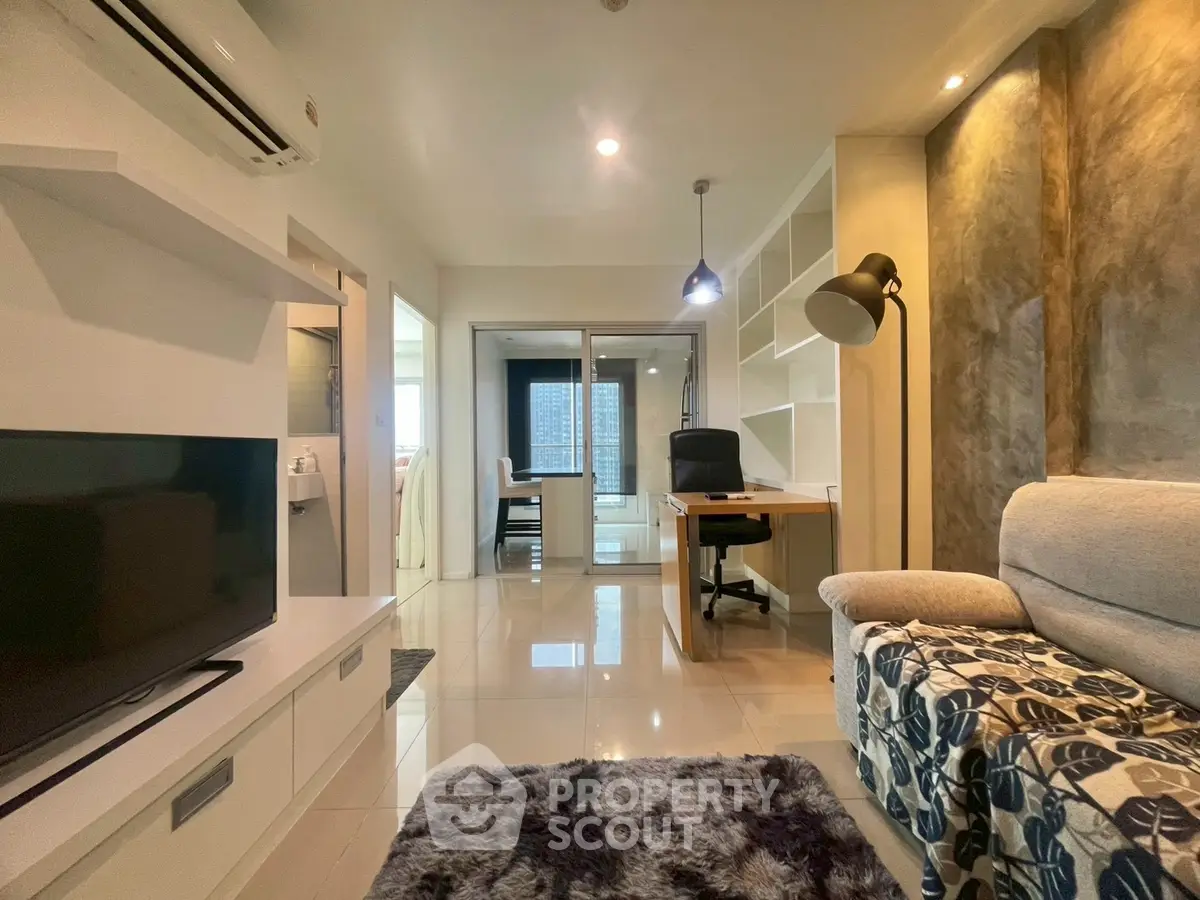 Modern living room with stylish decor and open study area, featuring sleek furniture and ambient lighting.