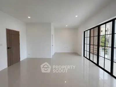 Spacious modern living room with large windows and sleek tile flooring