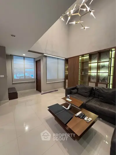Modern living room with sleek furniture and unique lighting in a stylish home.