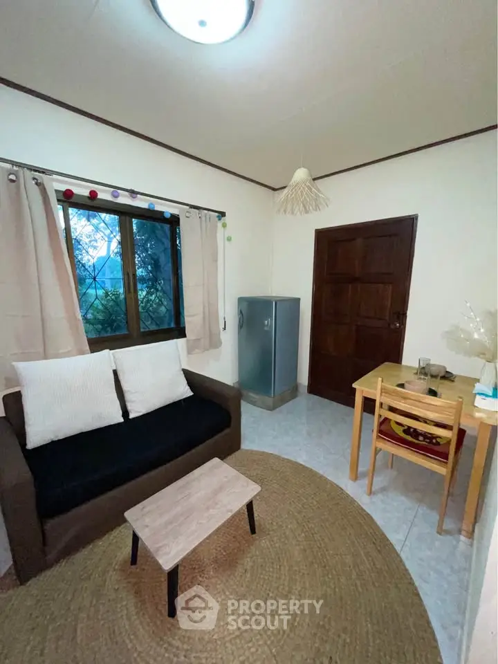 Cozy living room with sofa, small table, and window view.