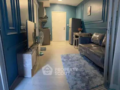 Cozy living room with modern decor and blue accents, featuring a plush rug and stylish furniture.