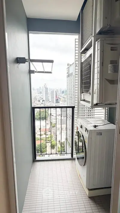 High-rise apartment balcony with laundry area and city view