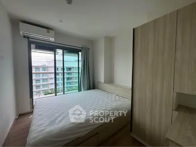 Modern bedroom with large window and wardrobe in urban apartment