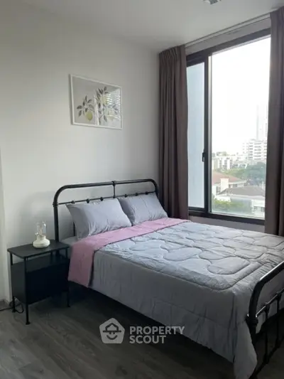 Modern bedroom with large window and stylish decor in urban apartment