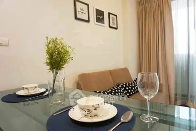 Modern living room with glass dining table and cozy sofa, perfect for urban living.