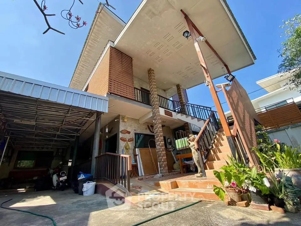 Charming two-story house with spacious balcony and lush garden, perfect for family living.