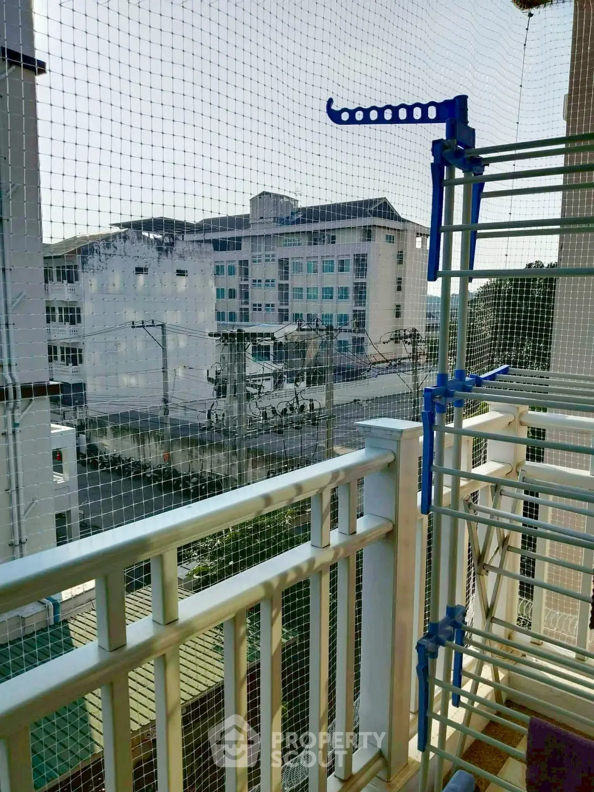 Charming balcony view with safety netting and drying rack, ideal for urban living.