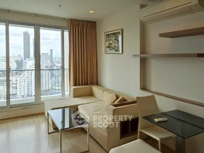 Modern living room with city view, featuring a cozy beige sofa and stylish shelves.