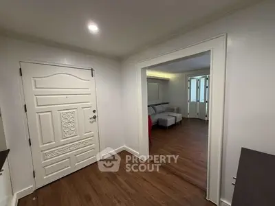 Spacious entryway leading to a cozy living room with elegant wood flooring and stylish decor.
