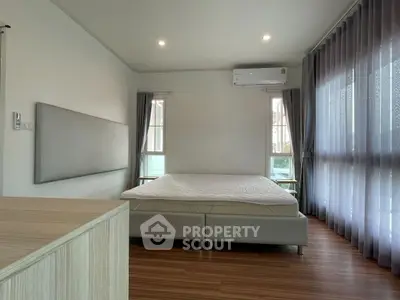 Spacious bedroom with modern design and large windows for natural light.