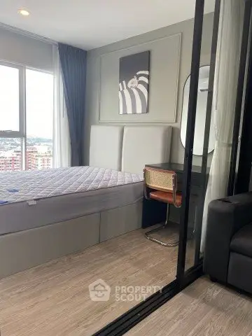 Modern bedroom with stylish decor and city view, featuring a comfortable bed and sleek furniture.