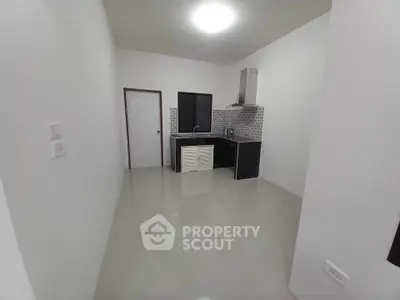 Modern minimalist kitchen with sleek black cabinets and tiled backsplash