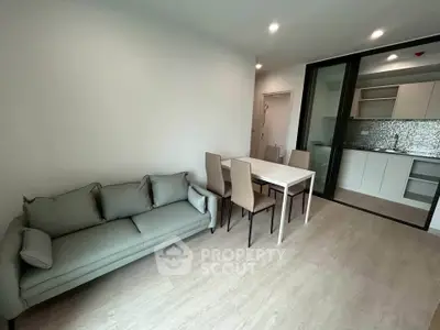 Modern living room with sleek furniture and open kitchen layout in a stylish apartment.
