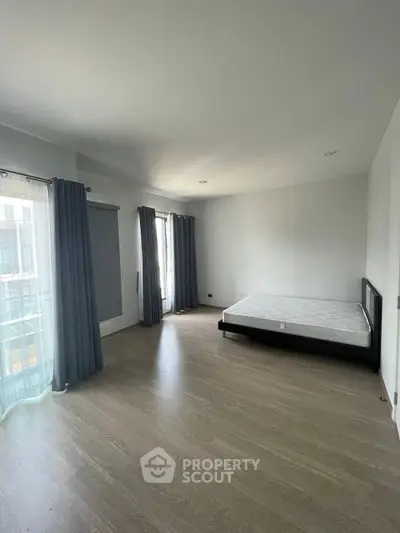Spacious bedroom with large windows and minimalist decor, perfect for natural light lovers.