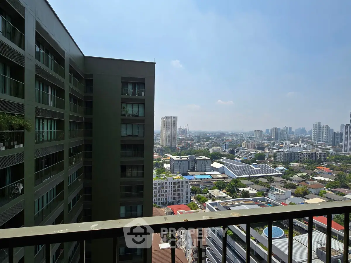 Stunning cityscape view from a high-rise balcony, showcasing urban skyline and modern architecture.