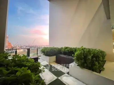 Stunning balcony with lush greenery and breathtaking city view at sunset.