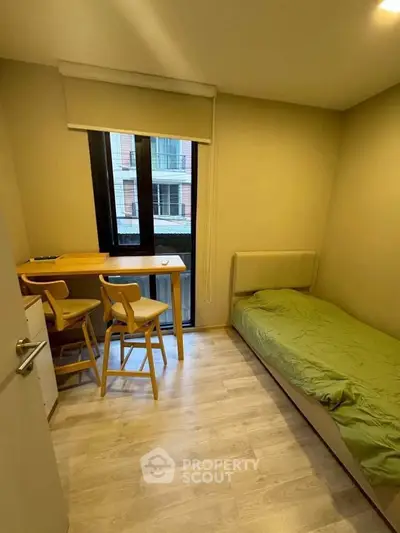 Cozy bedroom with single bed and study area, ideal for compact living spaces.