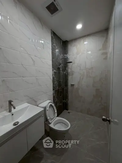 Modern bathroom with sleek tiles and contemporary fixtures in a stylish real estate property.