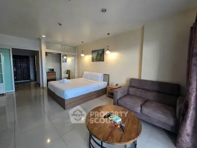 Spacious bedroom with modern furnishings and cozy seating area in a stylish apartment.