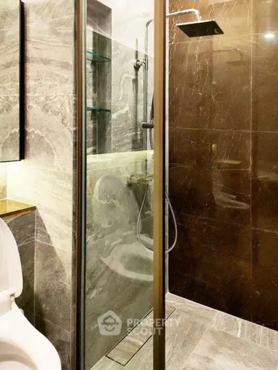 Luxurious modern bathroom with sleek marble tiles and glass shower enclosure.