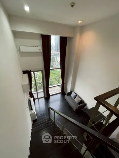 Modern loft with high ceilings and city view from balcony