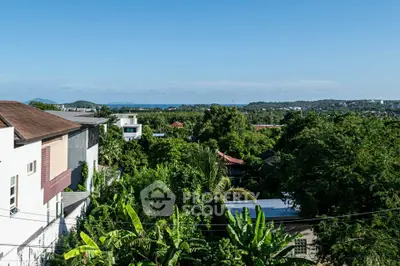 Stunning panoramic view of lush greenery and distant ocean from a high vantage point.