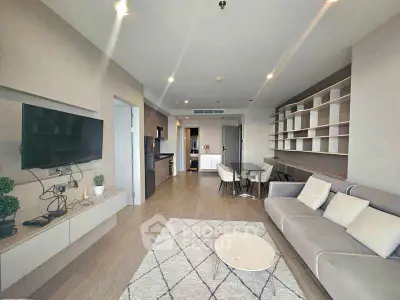 Modern living room with open layout, stylish furniture, and built-in shelving.